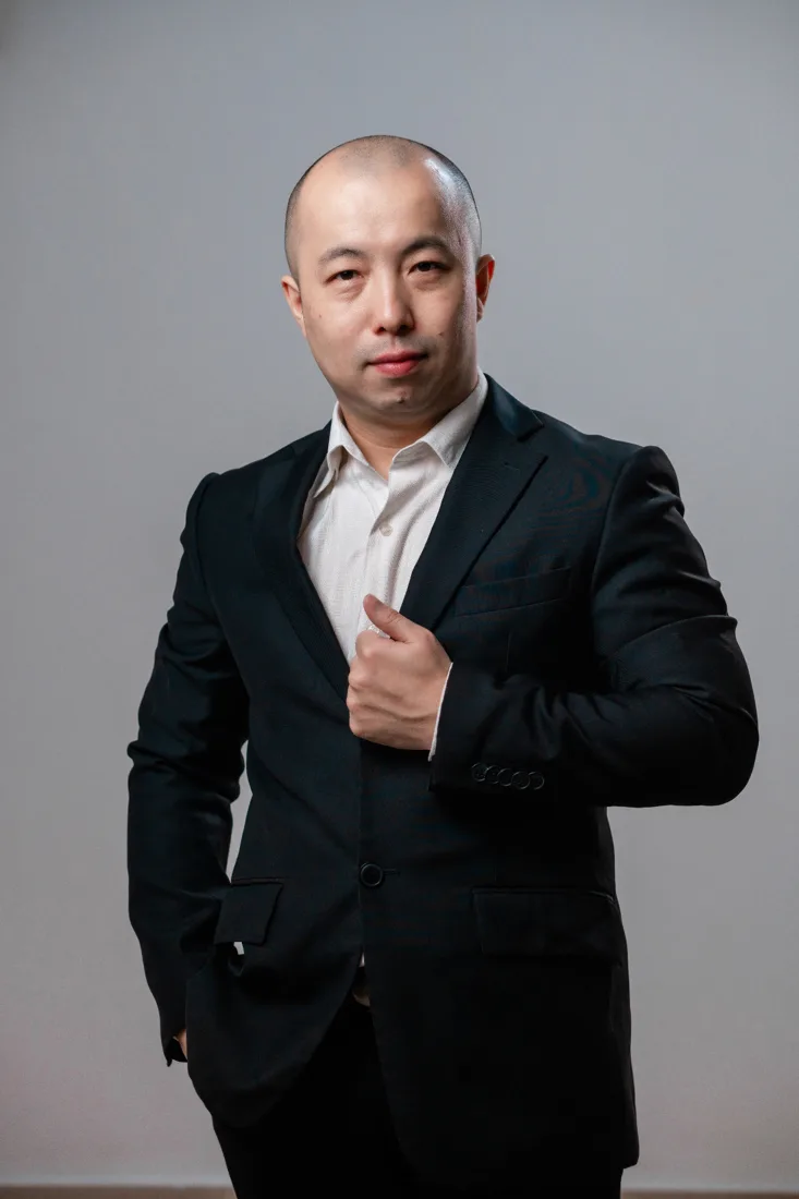 弈智棋院创办人林岳峰 Kenny Lim 身穿黑色西装